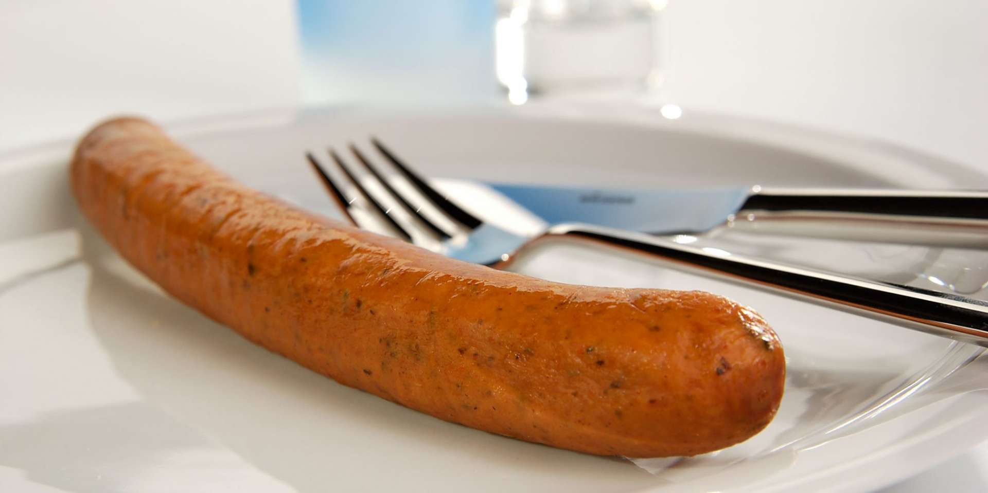 Eine Krakauer auf einem Teller mit Besteck.