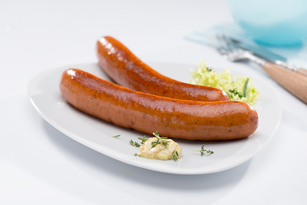 Damhus Rinds-Hot Dog, *25x60g, Eigenhaut Zwei Krakauer auf einem Teller.
